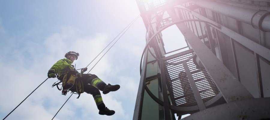 Man, fall arrest system, worker, hard hat, outside of building, safety guide to working at heights, working up high, falls to a lower level, safety culture, safety habits, safe behavioural patterns, PPE, SafeStart, SafeStart International, safety habits, workplace safety, occupational safety, improve safety culture, boost safety awareness, reduce human failure, reduce injuries, injury reduction, reduce accident rates, improve company figures, prevent critical errors, implement a positive culture change at your company, promote employee engagement, boost employee commitment, 24/7 safety, safety round the clock, being safe 24/7, safe behavioural patterns, learn safe behaviour, acquire universal safety skills, safety skill for families, safety skills for children, safety skills for everyone, safety training for employees, safety for the whole company, safety training for kids, improve operational efficiency, improve quality, safety-related habits, safety-related behaviour, risk patterns, ensure high performance, critical states, critical decisions, critical errors, how injuries occur, how to prevent injuries, how to prevent accidents